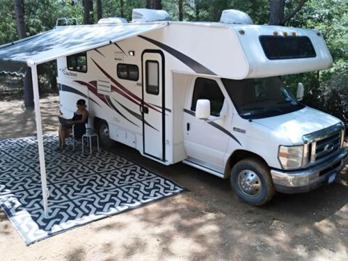 Parked RV with covered patio at site Harmony Ridge RV Park