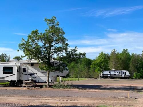 Parked trailers near open RV spaces at Wheelers RV Park