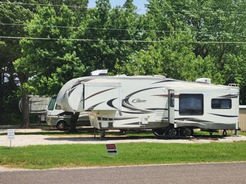 Fifth wheel with slide-out in paved site at Caravan RV