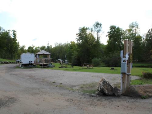 Open RV space near parked trailer at site Bear Ridge Campground & Cottages