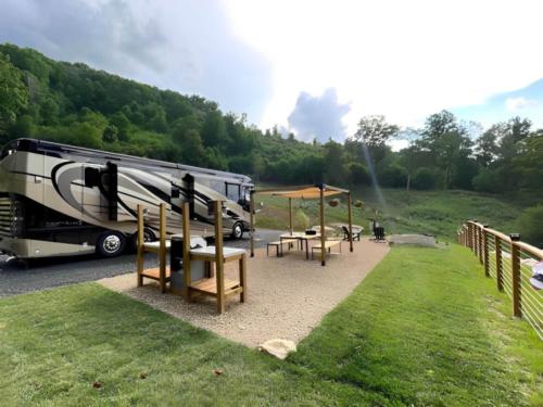 Parked RV with covered seating area at The Barlow RV Park