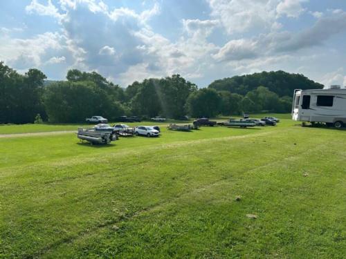 Vehicles parked on a grassy area at Still Waters Campground