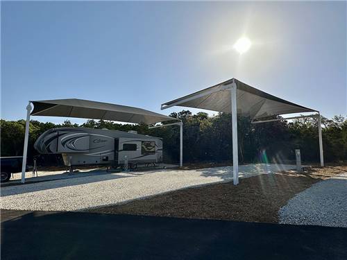 A travel trailer under an awning at site