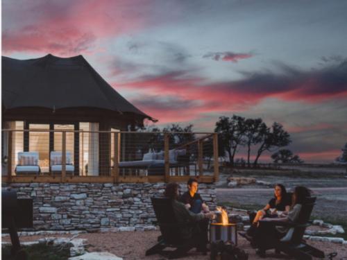 People around a fire ring at sunset at Outdoorsy Hill Country