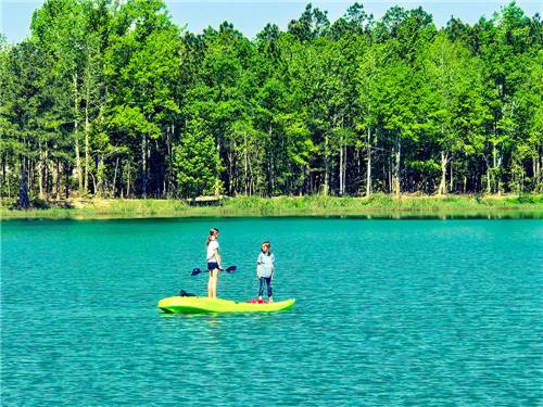Children standing on a kayak on the lake