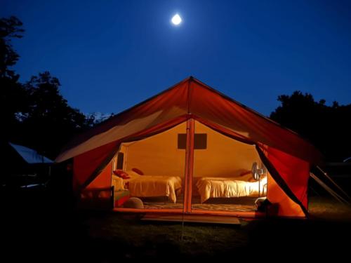 Night time view of tent at site Adirondack Safari