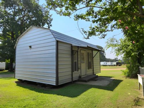 Cabin with RV's parked at site Amazing Acres RV Park