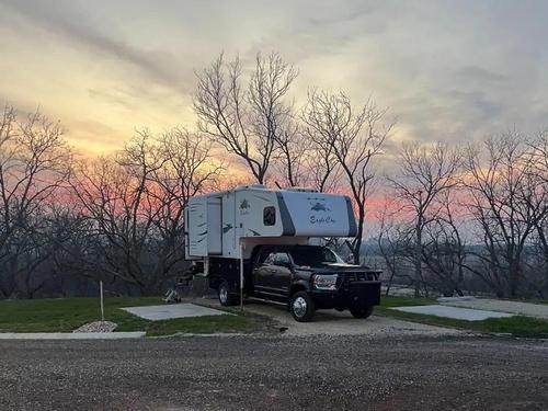 Camper parked with sun setting at Smoky Hill RV Park