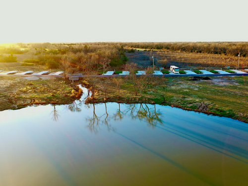 Aerial view of sites and pond at Ladera RV Resort