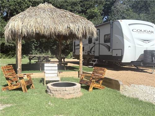 A thatched hut gazebo and fire pit at site