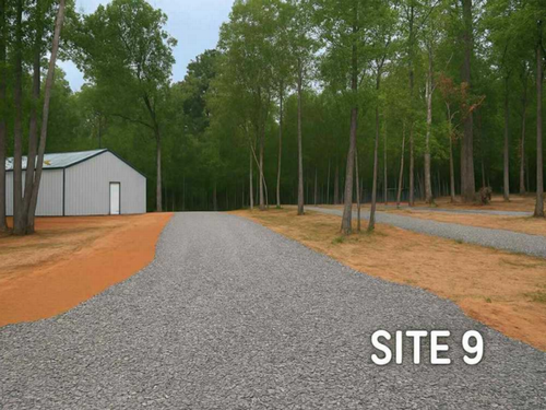 Site 9 with a building in the back Huckleberry Hideaway Cabins & RV Resort