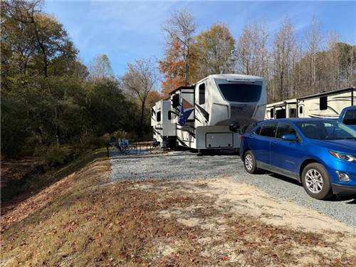 A blue car and fifth wheel parked at a site