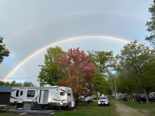 Parked trailer under a rainbow at Twin Ells Campsite