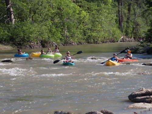 Kayakers and tubers on the river at PECAN PARK RIVERSIDE RV PARK