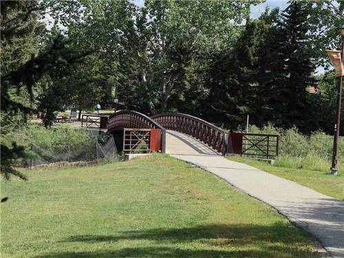 Footbridge arches over a stream at GRANDE PRAIRIE REGIONAL TOURISM ASSOCIATION