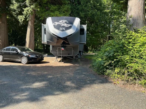 A fifth wheel RV and car at site at Sun Retreats Birch Bay