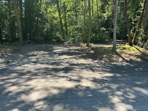 A shaded gravel sites and picnic table at Sun Retreats Birch Bay