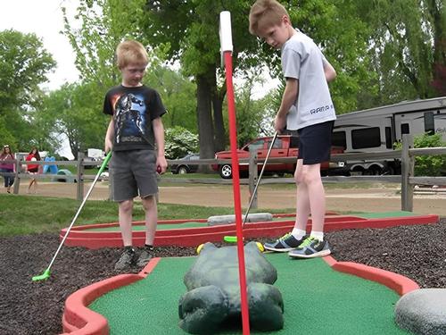 Kids playing mini golf