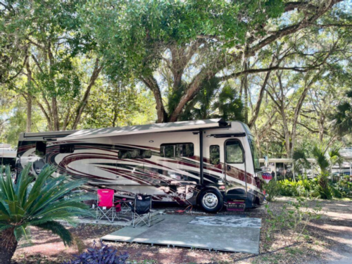 RV in tree lined site at Thousand Palms RV Resort