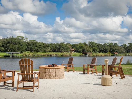 Chairs around a firepit with lake views at Moss Landing RV Resort