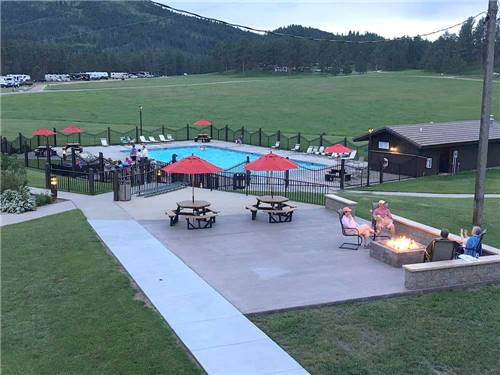 Swimming pool with outdoor seating at Rafter J Bar Ranch Camping Resort