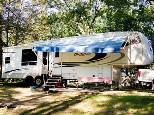 An RV parked in a shady site