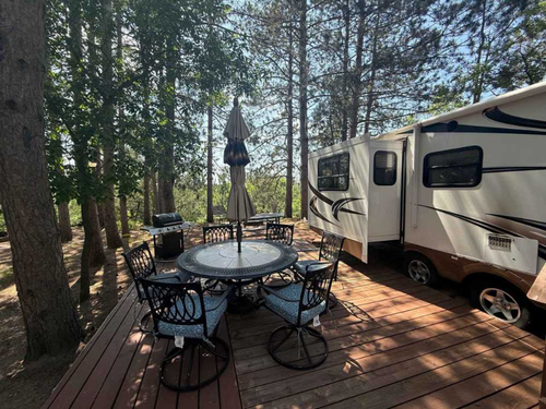 RV parked in site with deck and table