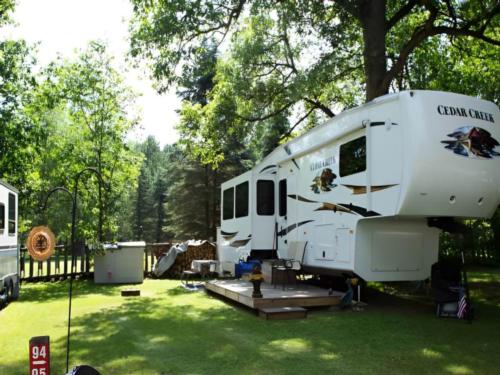 An RV parked in a shady site