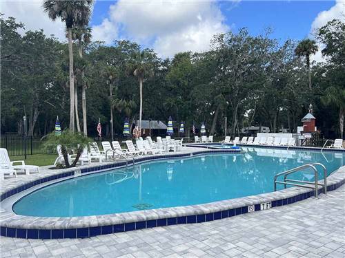 The swimming pool with lounge chairs at SUGAR MILL RUINS TRAVEL PARK