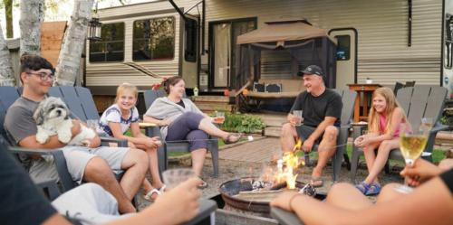 A family around a campfire in an RV site