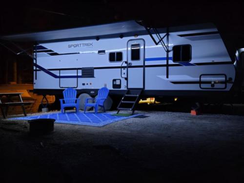 Parked trailer with covered patio at Ozark RV Park