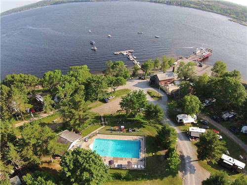 Aerial view of beautiful pool, woods, and lake with boats at HARDINGS POINT CAMPGROUND