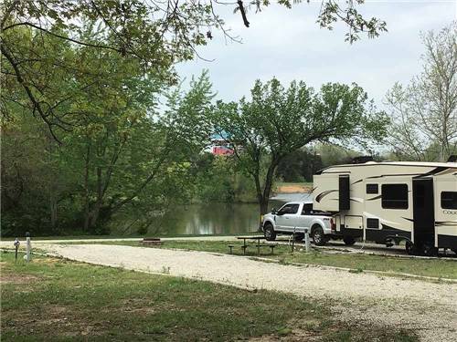 A long gravel RV site at RUSTIC TRAILS RV PARK