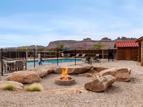 Fire pit with pool in the background at Sun Outdoors Canyonlands Gateway